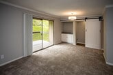 Located at 6315 Kingston Pike in Knoxville, Tennessee, this single-floor unit offers a well-organized layout with thoughtfully updated finishes throughout. The kitchen is a standout feature, equipped with white shaker-style cabinetry, granite-look countertops, a subway tile backsplash, a stainless steel over-the-range microwave, a black electric range, and a dishwasher. Wood-look plank flooring runs through the kitchen and connecting hallway, adding warmth and durability to the space. A decorative wine rack built into the cabinetry adds a distinctive touch.

The living area is generously sized, featuring neutral carpet, crown molding, and a sliding glass door that opens to a private balcony with outdoor views. A stylish barn door accent and built-in cabinetry nook add character to the room. The bedrooms are carpeted and bathed in natural light from window blinds, with the primary bedroom offering dual closets for substantial storage. An additional bedroom provides a bright, comfortable space with its own window.

The bathroom features white tile flooring, a tiled shower-tub combination, a granite-top vanity, and brushed nickel fixtures, maintaining a clean and cohesive aesthetic. Neutral gray walls and textured ceilings are consistent throughout, giving the entire unit a fresh, move-in-ready feel.