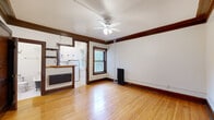 Located at 443 Ashland Ave in Saint Paul's historic Cathedral Hill neighborhood, this compact yet well-appointed unit showcases classic early 20th-century architectural details throughout. Rich, dark wood trim and baseboards frame every room, complementing the warm hardwood floors that run continuously across the living space and closet area. The living room is the heart of the unit, featuring a ceiling fan with light fixture, a cast-iron radiator for efficient heating, and a window that brings in natural light. A half-wall with a butcher block counter separates the living area from the efficiently designed kitchen, which is equipped with white cabinetry, a gas range, refrigerator, and a sink — all neatly organized to maximize functionality within a compact footprint. The bathroom is a standout feature, boasting a classic clawfoot soaking tub with overhead shower, a modern pedestal sink, penny-tile flooring, built-in shelving, and an additional cast-iron radiator — a thoughtful blend of vintage character and practicality. A dedicated closet with a full-width shelf and hanging rod provides organized storage. Throughout the unit, the consistent use of original woodwork, hardwood flooring, and period-appropriate details gives the space a cohesive, charming character.