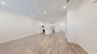 Located at 3800 W Lamberth Rd in Sherman, TX, this two-story home offers a thoughtfully designed layout across two floors. The main level features an open-concept kitchen and living area bathed in natural light from multiple windows dressed with white blinds. The kitchen is appointed with crisp white shaker cabinets, a quartz-topped island, stainless steel appliances including a French door refrigerator and range with microwave, and pendant lighting — all set above durable wood-look luxury vinyl plank flooring that extends throughout the main level. The living room provides a generous, versatile space with a clean, bright aesthetic.

Upstairs, three bedrooms feature plush carpeting and ample natural light. The primary bedroom includes a ceiling fan, a walk-in closet with wire shelving, and an en-suite bathroom. The additional bedrooms are well-proportioned with closet access. All three bathrooms maintain a consistent modern design with white tile, updated vanities, and brushed gold fixtures. A dedicated laundry room accommodates a full-size washer and dryer side by side. Throughout the home, recessed lighting, white walls, and clean architectural lines create a cohesive, contemporary feel.