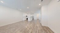 Located at 3800 W Lamberth Rd in Sherman, TX, this two-story home offers a thoughtfully designed layout across two floors. The main level features an open-concept kitchen and living area bathed in natural light from multiple windows dressed with white blinds. The kitchen is appointed with crisp white shaker cabinets, a quartz-topped island, stainless steel appliances including a French door refrigerator and range with microwave, and pendant lighting — all set above durable wood-look luxury vinyl plank flooring that extends throughout the main level. The living room provides a generous, versatile space with a clean, bright aesthetic.

Upstairs, three bedrooms feature plush carpeting and ample natural light. The primary bedroom includes a ceiling fan, a walk-in closet with wire shelving, and an en-suite bathroom. The additional bedrooms are well-proportioned with closet access. All three bathrooms maintain a consistent modern design with white tile, updated vanities, and brushed gold fixtures. A dedicated laundry room accommodates a full-size washer and dryer side by side. Throughout the home, recessed lighting, white walls, and clean architectural lines create a cohesive, contemporary feel.