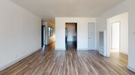 This single-floor, 2-bedroom, 1-bathroom residence offers a well-organized layout designed for comfortable everyday living. Wood-look flooring runs consistently throughout the unit, providing a cohesive and easy-to-maintain foundation in every room.

The open living area is bright and spacious, benefiting from natural light that filters through windows and a sliding glass door. A ceiling fan with a light fixture adds both functionality and airflow to the space. The layout connects the living area directly to the galley-style kitchen, which features dark espresso cabinetry, granite-look countertops, and black appliances including a refrigerator, range, and microwave — maximizing storage and counter space within an efficient corridor design.

Both bedrooms are well-sized with clean white walls, wood-look flooring, and ample closet space. One bedroom includes a sliding door closet with built-in shelving, offering practical organization. Each room benefits from natural light and a neutral palette that allows for versatile use.

The full bathroom is clean and functional, featuring a shower-tub combination with a sliding glass enclosure, a white vanity with an undermount sink, and wood-look flooring that ties the space together. A frosted window provides natural light while maintaining privacy throughout.