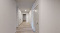 This single-floor residence at 13045 Tesson Ferry Rd in Saint Louis, MO offers a thoughtfully designed layout with contemporary finishes throughout. The interior is defined by a clean, neutral palette of crisp white walls and light hardwood-style flooring that flows through the main living and common areas, creating a bright and cohesive aesthetic.

The kitchen is a standout feature, outfitted with white shaker-style cabinetry, sleek white quartz countertops, a subway tile backsplash, and stainless steel appliances including a refrigerator, dishwasher, and range. Matte black hardware adds a modern contrast throughout. A kitchen island provides additional prep and gathering space.

The main living area benefits from soaring exposed ceiling beams, track lighting, and direct access to a private balcony through large windows fitted with horizontal blinds, inviting natural light and outdoor views.

Bedrooms feature plush carpet flooring and generous walk-in closet space with built-in shelving. The bathroom includes a wide vanity with quartz countertops, an undermount sink, matte black fixtures, and a large mirror with a shower area. A dedicated laundry room houses a full-size washer and dryer alongside the water heater and HVAC system. A well-lit hallway connects all rooms seamlessly.