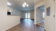 Located at 3995 Cracker Cove Ln in Canal Winchester, Ohio, this single-floor, two-bedroom, two-bathroom home offers a well-organized and functional layout. The combined kitchen and living area forms the heart of the home, with the living room showcasing rich, dark hardwood-style flooring and a classic chandelier overhead. French doors flood the space with natural light and open to an outdoor view, creating a bright and inviting atmosphere. A half-wall partition subtly divides the dining and living areas.

The galley-style kitchen is efficiently designed with warm honey-toned cabinetry, grey laminate countertops, and light vinyl flooring. It is equipped with a full suite of appliances including an electric range, microwave, dishwasher, and refrigerator.

Both bedrooms are carpeted for comfort. The generously sized primary bedroom features dark hardwood-style flooring and access to a large walk-in closet outfitted with wire shelving on multiple walls, offering ample storage. The second bedroom is carpeted and well-proportioned. Each bathroom includes a full tub-shower combination, a single-sink vanity with wood cabinetry, and clean white fixtures. A utility room rounds out the home's practical amenities.