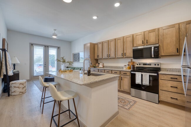 Cocina moderna con una amplia isla y diseño abierto en Residence at Pearsall Park. - Residences at Pearsall Park - A 55+ Community