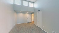 Located at 7415 Tallow Wind Trl in Fort Worth, TX, this single-floor residence offers a thoughtfully designed layout with a variety of notable architectural features. The living area immediately impresses with dramatically soaring ceilings and a bank of high clerestory windows that flood the space with natural light. Recessed lighting complements the abundant daylight, while neutral-toned carpet and smooth walls provide a clean, move-in-ready aesthetic throughout.

The kitchen is equipped with dark espresso-toned cabinetry, a peninsula breakfast bar with a light countertop surface, and a range with overhead ventilation hood. Hardwood-style flooring anchors the kitchen, which opens toward the carpeted living and dining areas via mirrored sliding doors, enhancing the sense of openness.

The bedrooms offer comfortable proportions, each with plush carpeting, closet access, and vaulted or angled ceilings that add visual interest. One bedroom features a sliding door opening to the exterior. The bathroom includes a full soaking tub and shower combination, surrounded by neutral ceramic tile that extends from floor to ceiling, providing a clean and functional finish.

Overall, this home presents a practical and inviting interior, combining open-concept living spaces with well-defined private areas in a quiet Fort Worth neighborhood.