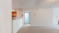 This 2-bedroom, 2-bathroom home in Columbia, MD offers a well-designed single-floor layout with a variety of notable features throughout. The living area is highlighted by dramatic vaulted ceilings with a ceiling fan, plush wall-to-wall carpeting, and a tile-surround wood-burning fireplace with a white mantel — creating a warm and inviting focal point. Sliding glass doors open onto a private balcony, filling the space with natural light and offering pleasant views of the surrounding greenery.

The kitchen is thoughtfully equipped with warm honey-toned wood cabinetry, generous counter space, a full suite of white appliances including an electric range and refrigerator, and tile flooring. A convenient in-unit washer and dryer is tucked behind sliding doors just off the kitchen, adding everyday practicality.

Both bedrooms are carpeted and well-proportioned. The primary bedroom benefits from a large window that brings in abundant natural light, along with access to additional rooms. The second bedroom features a walk-in style closet with built-in shelving. Neutral tones throughout the home create a clean, versatile canvas ready for personalization. This residence combines comfort and functionality in a desirable Columbia location.