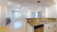 Located at 8020 W Manchester Ave in the Playa del Rey neighborhood of Los Angeles, this single-floor residence offers a well-appointed, functional layout with thoughtful finishes throughout. The open-concept kitchen features granite countertops, a breakfast bar peninsula, white cabinetry, stainless steel appliances including a refrigerator, range, and dishwasher, and flows seamlessly into the main living area. The living room is highlighted by gleaming hardwood flooring, crown molding, track lighting, and a granite-surround fireplace that serves as a striking focal point. Natural light enters through large windows dressed with vertical blinds. Two carpeted bedrooms provide comfortable retreats, each with windows offering neighborhood views and ample closet space. The primary bathroom is equipped with a granite-topped vanity, white cabinetry, and a glass-enclosed shower stall, while the secondary bathroom features a tub and shower combination with sliding glass doors and tile flooring. The neutral color palette and clean finishes throughout create a bright, cohesive ambiance well-suited to the Southern California lifestyle.