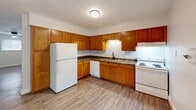 Located at 1308 W Covington Ct in Peoria, Illinois, this 2-bedroom, 1-bathroom residence offers a practical and comfortable single-floor layout. Light wood-style flooring runs throughout the home, creating a cohesive and clean aesthetic in every room.

The kitchen is a functional highlight, featuring warm honey-toned wood cabinetry that extends to the ceiling for generous storage, dark countertops, and white appliances including a refrigerator, electric range, and dishwasher. A ceiling-mounted light fixture illuminates the space efficiently.

Both bedrooms are bright and well-proportioned, each equipped with a ceiling fan and natural light from windows overlooking greenery. The primary bedroom includes a double-door closet, while the second bedroom features mirrored sliding closet doors. The neutral white walls throughout provide a clean, move-in-ready canvas.

The bathroom is neatly appointed with a warm wood vanity, white countertop, black hardware accents, and a full shower-tub combination. Wood-style flooring continues seamlessly into this space.

A hallway connects the rooms, and the overall layout is efficient and easy to navigate. The home's consistent use of light tones and natural light from multiple windows gives it an open, airy feel throughout.
