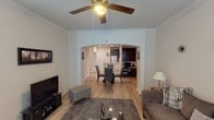 This single-floor residence offers a thoughtfully designed open layout that connects the main living spaces with ease. The living room serves as the heart of the home, featuring light wood-style flooring, crown molding, a ceiling fan, and ample natural light from multiple windows dressed with white blinds. A decorative arched pass-through with column detailing frames the transition into the dining and kitchen areas, adding architectural character.

The kitchen is well-equipped with dark espresso cabinetry, light granite-style countertops, and a full suite of stainless steel appliances including a refrigerator, range, and built-in microwave. Light wood-style flooring continues throughout, and recessed lighting keeps the space bright and functional. An adjacent area conveniently houses a side-by-side washer and dryer alongside additional cabinetry for storage.

The bedroom is a comfortable retreat with plush carpet flooring, a ceiling fan, and windows providing natural light. The bathroom features dark cabinetry with granite-style countertops, wood-style tile flooring, and a shower-tub combination. Throughout the residence, a neutral color palette and consistent finishes create a cohesive and inviting ambiance.