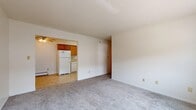 Located at 321 S Fifth St in Ames, Iowa, this compact 510-square-foot, single-floor apartment offers a practical and complete layout consisting of a living room, kitchen, bedroom, bathroom, and closet. The carpeted living room features neutral white walls and connects openly to the entry area, which has tile flooring. Ceiling fans are present in both the living room and the 120-square-foot bedroom, providing additional air circulation. The bedroom includes a baseboard heater, a window for natural light, and a wall-mounted air conditioning unit, ensuring year-round comfort. The kitchen is equipped with warm oak cabinetry, light countertops, tile flooring, and white appliances including a refrigerator, electric range, and dishwasher. The bathroom features a wood-toned vanity, tile flooring, a medicine cabinet mirror, and a tiled tub/shower combination with a distinctive yellow bathtub. Throughout the unit, baseboard heating is consistent, and the overall color palette of whites and warm wood tones creates a clean, functional living environment well-suited for a single occupant or student in the Ames area.