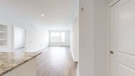This 1,000-square-foot, single-floor apartment at 580 South Goddard Boulevard in King of Prussia, Pennsylvania offers a well-designed layout with 2 bedrooms, 2 bathrooms, 2 closets, and a dedicated laundry room. The open-concept kitchen and living area serves as the heart of the unit, showcasing a large granite-topped island with an undermount sink, white shaker cabinetry, a white subway tile backsplash, and a full suite of stainless steel appliances including a French door refrigerator, electric range, and microwave. Recessed lighting and wood-look luxury vinyl plank flooring carry throughout the common areas, creating a cohesive, contemporary feel. The living room is bright and open, with multiple windows that bring in natural light. Both bedrooms feature ceiling fans, wood-look flooring, and generous natural light, with the primary bedroom measuring 150 square feet. The primary bathroom is finished with large-format marble-style tile flooring, a granite vanity, a glass-enclosed shower, and direct access to a walk-in closet. The second bathroom mirrors the same elegant tile and granite finishes, offering a full tub-shower combination. The in-unit laundry room includes an Electrolux front-load washer and overhead wire shelving for added storage convenience.