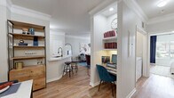 Located at 11666 Gulf Pointe Dr in Houston, TX, this single-story, one-bedroom, one-bathroom residence offers a thoughtfully designed layout finished with warm hardwood-style flooring and crown molding throughout. The open-concept living room is bright and welcoming, featuring a ceiling fan, large windows that invite natural light, and direct access to an exterior door. The kitchen is a standout, boasting crisp white cabinetry, stainless steel appliances, a deep single-basin sink with a matte black faucet, and a generous marble-topped peninsula that comfortably accommodates bar seating — ideal for casual dining or entertaining. A cleverly integrated built-in desk nook with shelving provides a dedicated workspace just off the main living area. The bedroom is comfortably sized, featuring a ceiling fan, large windows with outdoor views, crown molding, and direct access to a walk-in closet. The full bathroom includes a tub-shower combination. Completing the unit is a dedicated laundry room equipped with a full-size washer and dryer. The overall ambiance is clean, modern, and functional, making this a well-rounded residential space.