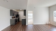 Located in the Palms neighborhood of Los Angeles, this single-floor residence at 3344 Castle Heights Ave offers a thoughtfully designed layout with modern finishes throughout. The open-concept living and dining area is anchored by rich, dark hardwood-style flooring and crisp white walls, creating a clean and contemporary aesthetic. Large windows with vertical blinds flood the space with natural light, while a ceiling fan adds comfort and character. A sliding glass door connects the living area to a private outdoor balcony, providing pleasant outdoor views. The galley-style kitchen is a standout feature, equipped with dark espresso cabinetry, sleek white quartz countertops, a tile backsplash, and a full suite of stainless steel appliances including a gas range, microwave, refrigerator, and dishwasher. The bedroom is carpeted for warmth and comfort, with generous natural light from a large window. Two well-appointed bathrooms feature wood-toned vanities with stone countertops, chrome fixtures, and full tub-shower combinations with curved curtain rods. The unit also includes a separate carpeted room accessible via a sliding door, ideal as an additional bedroom or flex space. Overall, the residence delivers a polished, move-in-ready experience in a desirable Los Angeles location.