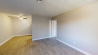 This 1-bedroom, 1-bathroom unit offers a practical and well-designed layout across a single floor. The open-concept living and kitchen area is finished with durable wood-style luxury vinyl plank flooring, neutral warm-toned walls, and a textured ceiling with a ceiling fan, creating a bright and welcoming atmosphere. A vertical blind-covered window allows natural light to fill the living space.

The kitchen is efficiently appointed with white shaker-style cabinetry extending to the ceiling for ample storage, a light-colored countertop, subway tile backsplash, and black appliances including a full-size refrigerator, dishwasher, and electric range, all complemented by light vinyl plank flooring.

The bedroom is a comfortable, well-proportioned room featuring plush carpeting, a window with an outdoor view, and a textured ceiling, offering a quiet and restful retreat. A closet with convenient access is also present.

The bathroom is neatly finished with wood-style flooring, a white vanity with a granite-patterned countertop, a full tub and shower combination, and brushed nickel fixtures throughout, adding a clean and modern touch. The overall ambiance of the unit is clean, neutral, and move-in ready.