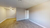This 1-bedroom, 1-bathroom unit offers a practical and well-designed layout across a single floor. The open-concept living and kitchen area is finished with durable wood-style luxury vinyl plank flooring, neutral warm-toned walls, and a textured ceiling with a ceiling fan, creating a bright and welcoming atmosphere. A vertical blind-covered window allows natural light to fill the living space.

The kitchen is efficiently appointed with white shaker-style cabinetry extending to the ceiling for ample storage, a light-colored countertop, subway tile backsplash, and black appliances including a full-size refrigerator, dishwasher, and electric range, all complemented by light vinyl plank flooring.

The bedroom is a comfortable, well-proportioned room featuring plush carpeting, a window with an outdoor view, and a textured ceiling, offering a quiet and restful retreat. A closet with convenient access is also present.

The bathroom is neatly finished with wood-style flooring, a white vanity with a granite-patterned countertop, a full tub and shower combination, and brushed nickel fixtures throughout, adding a clean and modern touch. The overall ambiance of the unit is clean, neutral, and move-in ready.