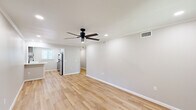 This well-appointed one-bedroom, one-bathroom unit in Metairie, Louisiana offers a clean, modern aesthetic throughout its single-floor layout. Light wood-look flooring spans every room, creating a cohesive and bright atmosphere complemented by neutral gray-toned walls and crisp white trim and baseboards.

The open living area is spacious and airy, featuring recessed lighting, a sleek black ceiling fan, and ample room to arrange a variety of furniture configurations. A sliding glass door connects the space to an outdoor patio area, allowing natural light to pour in and providing easy access to the fenced exterior.

The kitchen is thoughtfully designed with gray shaker-style cabinetry, white quartz countertops, a matte black pull-down faucet, and a window that brings in additional natural light. A stainless steel refrigerator and dishwasher are included, enhancing both function and style.

The bedroom is generously sized with a ceiling fan, a large window with blinds, and recessed lighting. A hallway with crown molding detail connects the main living areas to the bedroom and bathroom, lending an elevated feel to the space.

The bathroom features light wood-look flooring, a white vanity with a clean-lined countertop, a tub/shower combination, matte black hardware and towel bars, and a window for natural ventilation. The overall design is clean, modern, and move-in ready.