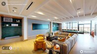 Located at 1001 Hammel Dr in Raleigh, NC, this thoughtfully designed amenity floor delivers a generous, single-level layout ideal for gathering, working, and entertaining. The space is anchored by two distinct living areas: one centered around a large flat-screen TV with plush, modular sectional seating, bold mustard and teal accent chairs, and exposed beam ceilings; the other featuring a billiards table, a built-in teal stone accent wall with open shelving, and a window-side bar counter with city views. A well-appointed kitchenette runs along a wall of large windows, outfitted with matte green cabinetry, open display shelving, and modern appliances — flooding the area with natural light. A dedicated dining area showcases a striking geometric tile floor, a sleek dark conference-style table, and vibrant yellow upholstered chairs. The private office, enclosed with glass-paneled walls, offers a quiet retreat along the main hallway. A carpeted corridor lined with large windows connects the zones with ease. The space flows seamlessly onto an expansive outdoor terrace finished with wood-plank ceilings, ceiling fans, and modern furniture, offering sweeping panoramic views of the Raleigh skyline — an exceptional finishing touch to this vibrant, amenity-rich environment.