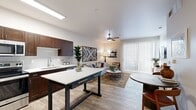 This efficient yet thoughtfully designed one-bedroom, one-bathroom unit offers a smart layout across a single floor. The open-concept kitchen and living area serves as the heart of the space, where rich dark-stained cabinetry, white quartz countertops, a subway tile backsplash, and stainless steel appliances — including a refrigerator, range, microwave, and dishwasher — create a functional and stylish kitchen. A freestanding island provides additional prep and dining space. Wood-look plank flooring runs throughout, lending warmth and continuity to the entire unit. The living area is bright and inviting, anchored by a ceiling fan and a full-height sliding glass door fitted with vertical blinds that fills the room with natural light and provides outdoor access. The bedroom is a comfortable retreat featuring a ceiling fan, a large window with natural light, and a dedicated walk-in closet with built-in shelving and hanging rods. The bathroom is cleanly finished with a dark-stained vanity, white countertop, and a full tub-shower combination. A separate laundry area completes the unit, adding everyday convenience to this well-appointed single-floor residence.