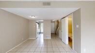 This two-story, two-bedroom, two-bathroom home in San Marcos, TX is thoughtfully laid out across two levels, offering a functional and comfortable living environment. The main floor features a bright living room finished with large tile flooring and a textured ceiling, with a sliding glass door that invites natural light and provides access to an outdoor patio area. The galley-style kitchen is well-equipped with dark cabinetry, light countertops, a dishwasher, and a large window overlooking a green outdoor setting, creating a pleasant atmosphere for cooking. A convenient bathroom on the main level features tile flooring, a vanity, and a tucked-in layout beneath the staircase. Upstairs, both bedrooms are finished with warm hardwood flooring and ceiling fans, with multiple windows offering outdoor views and ample natural light. The primary bedroom is generously sized and includes a large bifold closet. The second bedroom is equally well-appointed with its own closet. A full bathroom on the upper level features tile flooring, a vanity with countertop space, and a bathtub. Hallways on both levels connect the spaces efficiently, with a staircase linking the two floors. The overall design is clean and neutral, offering a versatile canvas throughout.