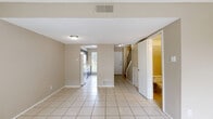 This two-story, two-bedroom, two-bathroom home in San Marcos, TX is thoughtfully laid out across two levels, offering a functional and comfortable living environment. The main floor features a bright living room finished with large tile flooring and a textured ceiling, with a sliding glass door that invites natural light and provides access to an outdoor patio area. The galley-style kitchen is well-equipped with dark cabinetry, light countertops, a dishwasher, and a large window overlooking a green outdoor setting, creating a pleasant atmosphere for cooking. A convenient bathroom on the main level features tile flooring, a vanity, and a tucked-in layout beneath the staircase. Upstairs, both bedrooms are finished with warm hardwood flooring and ceiling fans, with multiple windows offering outdoor views and ample natural light. The primary bedroom is generously sized and includes a large bifold closet. The second bedroom is equally well-appointed with its own closet. A full bathroom on the upper level features tile flooring, a vanity with countertop space, and a bathtub. Hallways on both levels connect the spaces efficiently, with a staircase linking the two floors. The overall design is clean and neutral, offering a versatile canvas throughout.