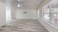 This two-story, 3-bedroom, 2-bathroom home in San Marcos, Texas offers a well-balanced layout split evenly across two floors. The main level features an open-concept kitchen and living room finished with light wood-look flooring throughout. The kitchen is equipped with white shaker-style cabinetry, marble-look countertops, and stainless steel appliances including a refrigerator, dishwasher, range with over-the-range microwave, and built-in overhead lighting that keeps the space bright and functional. The adjacent living room is airy and naturally lit, featuring a ceiling fan and windows with blinds that allow for ample natural light. Upstairs, three bedrooms are finished with neutral carpet and ceiling fans. The primary bedroom offers generous proportions with dual sliding closet doors providing substantial storage. Additional bedrooms also include closet space and windows for natural light. Both bathrooms are finished with wood-look tile flooring, white vanity cabinetry, marble-look countertops, and large mirrors. One bathroom features a tub-shower combination with tiled surround. A connecting hallway and staircase link the two levels seamlessly, creating a cohesive and practical floor plan throughout the home.