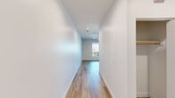 This contemporary 580 square foot apartment in Newport Beach offers a blend of modern design and efficient living. The space is thoughtfully laid out, featuring an open-plan living area that combines the kitchen and living room, maximizing the use of available space. The single bedroom, measuring 90 square feet, provides a cozy retreat.

The kitchen is a standout feature, boasting sleek white cabinetry that extends to the ceiling, providing ample storage. It's equipped with stainless steel appliances, including a built-in microwave, electric range, and refrigerator. Under-cabinet lighting illuminates the light-colored backsplash, enhancing the modern aesthetic.

Throughout the apartment, warm-toned hardwood flooring adds a touch of elegance and continuity. The living area is bright and airy, with clean white walls that reflect light and create a sense of spaciousness. A balcony accessible from the living area offers views of the street below, complete with palm trees that hint at the Southern California location.

The bedroom, while compact, features a large window that floods the space with natural light. Built-in closet space helps to maximize the room's functionality. The apartment's design emphasizes a minimalist approach, with recessed lighting and simple fixtures that contribute to the overall modern ambiance.

Located in the Eight 80 Newport Beach complex, this apartment combines style and functionality in a prime coastal setting, perfect for those seeking a contemporary living space in a desirable location.