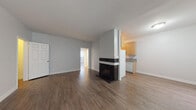 Located in the Mar Vista neighborhood of Los Angeles, this single-floor unit offers a well-organized layout with consistent wood-style flooring throughout. The spacious living room serves as the heart of the space, anchored by a striking black-tiled fireplace that adds a classic focal point. Large sliding glass doors fitted with vertical blinds allow natural light to fill the room while providing access to the exterior. A wall-mounted A/C unit ensures year-round comfort. The kitchen is designed in a galley configuration, featuring light wood cabinetry, granite-style countertops, a double-basin sink, and white appliances including a refrigerator and dishwasher. Overhead track lighting keeps the kitchen bright and functional. The primary bedroom is generously sized, with a wide window for natural light, a walk-in closet with wire shelving, and direct access to a private en-suite bathroom. The bathrooms are finished in clean white with tub-shower combinations and light wood-style flooring. An additional bedroom provides a quiet, well-lit space with its own window. Throughout the unit, crisp white walls and neutral tones create a bright, clean ambiance well-suited to the sunny Southern California lifestyle.