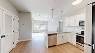 This well-appointed 2-bedroom, 2-bathroom residence at 50 Hazel St in Cheshire, CT offers a thoughtfully designed single-floor layout with modern finishes throughout. The open-concept kitchen and living area serves as the heart of the home, featuring white shaker cabinetry, granite countertops, a subway tile backsplash, stainless steel appliances, and a peninsula island with pendant lighting overhead. Light hardwood-style flooring flows seamlessly throughout the entire residence, enhancing the bright and airy atmosphere. The spacious primary bedroom includes large windows that invite abundant natural light and views of the surrounding scenery, complemented by a generous walk-in closet with built-in wire shelving. The second bedroom also features a wall-mounted mini-split system for individual climate control and a natural light-filled window. Both bathrooms are finished with white vanities and hardwood-style flooring; one features a soaking tub, while the other boasts a subway-tiled walk-in shower. Neutral gray tones on the walls create a clean, contemporary palette throughout. Two closets provide ample storage, and the overall layout is efficient and functional, making this residence a comfortable and stylish home in the heart of Cheshire, Connecticut.