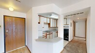 Located at 610 Stonehaven Dr in Ames, Iowa, this single-floor residence offers a practical and well-organized layout with two bedrooms, three bathrooms, and three closets. The unit is designed for efficient use of space throughout.

The kitchen is a standout feature, equipped with abundant white cabinetry accented by warm wood trim, generous counter space, a double sink, a black electric range, a dishwasher, and a full-size refrigerator. Tile flooring and a pass-through breakfast bar opening to the hallway add both function and a sense of openness. The kitchen receives overhead fluorescent lighting, keeping the space bright and practical.

The living room is carpeted and features a ceiling fan, a sliding glass door that provides natural light and outdoor access, and a clean, neutral palette throughout. Both bedrooms are carpeted as well, with white walls, wood-trimmed windows that bring in natural light, and a calm, understated ambiance. The primary bedroom offers a comfortable footprint with its own closet.

All three bathrooms are fitted with tub-shower combinations and tile flooring, maintaining a consistent and clean aesthetic. A connecting hallway ties the rooms together efficiently. The overall design is straightforward and functional, with neutral tones and warm wood accents providing a cohesive look throughout the home.