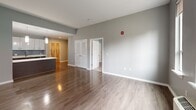 This well-appointed one-bedroom, one-bathroom unit at 4328 Ridge Ave in Philadelphia's East Falls neighborhood offers a thoughtfully designed open-concept layout. The combined kitchen and living area forms the heart of the home, featuring durable hardwood-style flooring that flows seamlessly throughout. The modern kitchen is equipped with stainless steel appliances, including an electric range, microwave, and refrigerator, complemented by sleek dark cabinetry with gold-tone hardware, white quartz countertops, a tile backsplash, and a peninsula with additional prep and storage space. A pendant light adds a refined touch overhead. The spacious living area receives generous natural light through large windows with views of the surrounding neighborhood, and includes a wall-mounted HVAC unit for year-round comfort. The bedroom offers plush carpeting, a double-door closet, and its own large window allowing ample daylight. The full bathroom features light-toned tile flooring, a floating dark-wood vanity with a white sink, a tub-shower combination, and a large mirror. Neutral gray tones are carried throughout the unit, creating a clean, contemporary aesthetic that is both inviting and functional.
