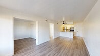 Located in Peoria, Arizona, this single-story 2-bedroom, 1-bathroom home offers a clean, modern aesthetic with a thoughtfully organized layout. The open-concept living and kitchen area forms the heart of the home, unified by durable wood-look flooring and bright white walls that reflect natural light throughout. A ceiling fan adds comfort to the living space, which is anchored by a large window that brings in views of the outdoors.

The kitchen is well-appointed with stainless steel appliances, including a refrigerator and range, complemented by white shaker cabinets, gray subway tile backsplash, and a peninsula featuring a quartz countertop, undermount sink with a matte black faucet, and open shelving below. An in-unit washer is also conveniently accessible from the kitchen area.

Both bedrooms are finished with matching wood-look flooring and feature closets for storage. The primary bedroom offers comfortable proportions, while the second bedroom includes a window with natural light and outdoor views. The full bathroom is crisp and clean, featuring a white vanity with storage, a tub-shower combination, and matching wood-look flooring. A hallway connects the bedrooms and bathroom, with additional closet and pantry storage rounding out the home's practical offerings.