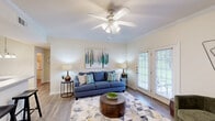 Located at 196 Jeff Rd NW in Huntsville, Alabama, this thoughtfully designed one-bedroom, one-bathroom unit offers a comfortable and functional single-floor layout. The living room serves as the heart of the space, featuring hardwood-style flooring, crown molding, and a ceiling fan with integrated lighting. Natural light pours in through a set of French doors that open to an outdoor area, creating an inviting and airy atmosphere. The kitchen is appointed with white cabinetry, tile flooring, and white appliances including a refrigerator, microwave, and electric range. A pass-through counter with bar seating connects the kitchen to the living area, enhancing the open feel. The spacious primary bedroom is finished with plush carpet, a ceiling fan, and a large window that frames greenery outside, contributing to a calm and restful environment. The bathroom includes a combination tub and shower, a vanity with storage, and hardwood-style flooring for a clean, cohesive look. A dedicated laundry room with wire shelving and washer/dryer hookups adds everyday convenience. Throughout, neutral tones and consistent finishes create a cohesive and welcoming ambiance.