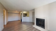 This two-bedroom, one-bathroom unit in Fishers, Indiana offers a well-organized single-level layout designed for comfortable everyday living. The open-concept living and dining area is a central highlight, featuring durable hardwood-style flooring and a tile-surround fireplace that serves as a natural focal point. Natural light fills the space through multiple windows fitted with blinds, creating a bright and welcoming atmosphere. The kitchen is positioned adjacent to the living area with a peninsula-style counter that defines the space without closing it off. It is equipped with dark cabinetry, granite-style countertops, stainless steel appliances including a refrigerator, range, microwave, and dishwasher, along with a window above the sink. Both bedrooms feature plush carpeting and ceiling fans with lighting, offering a comfortable and functional retreat. The primary bedroom provides a generous footprint with access to a walk-in closet featuring wire shelving. The shared full bathroom is tastefully appointed with dark vanity cabinetry, granite countertops, a framed mirror, and a tiled tub-shower combination. A hallway connects the private areas of the unit, and two closets provide ample storage throughout.