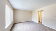Located at 5234 Boulder Dr in West Des Moines, IA, this 2-bedroom, 1-bathroom single-floor unit offers a functional and comfortable layout. The combined kitchen and living area serves as the heart of the home, where the kitchen features a galley-style design with white cabinetry, stone-patterned countertops, light wood-style flooring, and black appliances including a stainless range and refrigerator. The living room area is carpeted and filled with natural light from large windows with vertical blinds, offering views of the surrounding greenery. A front entry door with an adjacent window further brightens the space. Both bedrooms are carpeted and feature neutral beige walls, ceiling fans with light fixtures, and windows that let in natural light with outdoor views. The primary bedroom includes access to a dedicated closet, while the second bedroom also benefits from its own closet space. A hallway connects the bedrooms to the full bathroom, which is equipped with a shower/tub combo and chrome fixtures. Textured ceilings are featured throughout the living areas, adding subtle architectural character. The overall ambiance is clean, bright, and move-in ready.