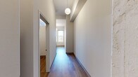 Located in the heart of downtown Milwaukee at 740 N Plankinton Ave, this one-bedroom, one-bathroom unit offers an efficient and well-designed layout across a single floor. Warm hardwood-style flooring flows throughout the space, lending a cohesive and modern feel to every room.

A long, well-lit hallway serves as the entry corridor, featuring a globe pendant light and clean neutral walls that guide you into the main living area. The open kitchen is thoughtfully equipped with white cabinetry, stainless steel appliances including a refrigerator and dishwasher, a built-in microwave, and a smooth cooktop — all beneath stylish pendant lighting and soaring ceilings with exposed structural elements that add an industrial character to the space.

The bedroom is a cozy, sun-filled retreat with multiple large windows that frame impressive city skyline views, bringing in abundant natural light. Sliding closet doors provide practical storage without sacrificing floor space.

The bathroom features a full soaking tub and shower combo with a clean white surround equipped with built-in shelving, offering both comfort and utility.

Throughout the unit, the neutral color palette, modern fixtures, and consistent flooring create a streamlined, contemporary ambiance ideal for urban living in Milwaukee's vibrant downtown district.