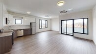 Located at 125 S Harrison Street in East Orange, NJ, this 2-bedroom, 2-bathroom unit showcases a clean, modern design throughout its single-floor layout. Wood-style luxury vinyl flooring flows consistently across all rooms, lending warmth and cohesion to the contemporary aesthetic defined by crisp white walls and clean lines.

The open-concept living and dining area is generously proportioned, bathed in natural light from large black-framed windows and sliding glass doors that open onto a private balcony overlooking the surrounding neighborhood. A ceiling-mounted HVAC cassette ensures year-round comfort.

The kitchen is well-appointed with two-tone cabinetry—glossy white upper cabinets and wood-grain lower cabinets—complemented by light stone countertops, a subway tile backsplash, and a full suite of stainless steel appliances including a refrigerator, dishwasher, range, and microwave.

Both bedrooms offer comfortable proportions, large black-framed windows with neighborhood views, and ceiling-mounted climate control. The two bathrooms maintain the unit's modern palette with white fixtures, vanities with mirrored medicine cabinets, and warm wood-tone flooring. The overall ambiance is bright, clean, and move-in ready.