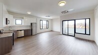 Located at 125 S Harrison Street in East Orange, NJ, this 2-bedroom, 2-bathroom unit showcases a clean, modern design throughout its single-floor layout. Wood-style luxury vinyl flooring flows consistently across all rooms, lending warmth and cohesion to the contemporary aesthetic defined by crisp white walls and clean lines.

The open-concept living and dining area is generously proportioned, bathed in natural light from large black-framed windows and sliding glass doors that open onto a private balcony overlooking the surrounding neighborhood. A ceiling-mounted HVAC cassette ensures year-round comfort.

The kitchen is well-appointed with two-tone cabinetry—glossy white upper cabinets and wood-grain lower cabinets—complemented by light stone countertops, a subway tile backsplash, and a full suite of stainless steel appliances including a refrigerator, dishwasher, range, and microwave.

Both bedrooms offer comfortable proportions, large black-framed windows with neighborhood views, and ceiling-mounted climate control. The two bathrooms maintain the unit's modern palette with white fixtures, vanities with mirrored medicine cabinets, and warm wood-tone flooring. The overall ambiance is bright, clean, and move-in ready.