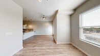 Located at 109 N Lexington St in Manor, TX, this well-designed single-story home offers a thoughtfully laid-out 1-bedroom, 1-bathroom floor plan with a clean, modern aesthetic throughout. Light wood-look flooring runs continuously across the entire home, creating a cohesive and airy feel.

The open-concept kitchen and living area serves as the heart of the home. The kitchen is outfitted with white shaker-style cabinetry, granite countertops, a gray subway tile backsplash, stainless steel appliances including a refrigerator, range, microwave, and dishwasher, and a peninsula with pendant lighting that anchors the space. A ceiling fan overhead enhances comfort in the living area.

A long, well-lit hallway connects the main living spaces to the private bedroom wing, lined with recessed lighting and crisp white doors. The generously sized primary bedroom features vaulted ceilings, a ceiling fan, and a large window that brings in abundant natural light and outdoor views. A dedicated closet provides ample storage.

The bathroom is finished with floor-to-ceiling neutral tile surrounding a soaking tub and shower combination, offering a clean and spa-like atmosphere. Every detail of this home reflects a fresh, modern build designed for comfortable everyday living.