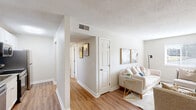 This thoughtfully designed single-floor residence in Lexington, SC offers three bedrooms, one bathroom, and a practical, comfortable layout. The living room is bright and welcoming, featuring warm hardwood-style flooring, neutral walls, and a textured ceiling. Natural light filters through the windows, creating an airy atmosphere well-suited for relaxing or entertaining.

The kitchen is efficiently laid out and features white shaker-style cabinetry, granite-look countertops, stainless steel appliances including a refrigerator, range, microwave, and dishwasher, and a bold blue accent wall that adds a pop of color. Hardwood-style flooring continues throughout the main areas, providing a cohesive look.

A hallway connects the living spaces to the bedrooms, each finished with plush carpeting and offering ample closet storage, including a walk-in closet with built-in shelving in one bedroom. The bedrooms maintain a calm, neutral palette with textured ceilings, making them versatile and comfortable retreats.

The full bathroom includes a tub-shower combination with clean white surround panels, a granite-look vanity countertop, and wood-style flooring. Throughout the residence, clean white trim, six-panel doors, and a consistent neutral color scheme create a cohesive and move-in ready environment.