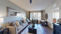 This thoughtfully designed single-floor residence offers a cohesive layout that balances comfort and functionality. The living room serves as the heart of the home, featuring rich hardwood flooring, soft sage-green accent walls, and a ceiling fan overhead. Large windows dressed with layered curtains and blinds invite abundant natural light, while a decorative wall mirror adds depth to the space. A plush area rug and dark wood coffee table anchor the seating arrangement.

Adjacent to the living room, the dedicated dining area features hardwood flooring, an overhead chandelier, and space for a four-person table, making it ideal for everyday meals or entertaining. Coastal-inspired artwork adds a finishing touch to the nook.

The galley-style kitchen is outfitted with rich dark cabinetry, granite-style countertops, a mosaic tile backsplash, tile flooring, and full black appliance suite including a refrigerator, range, and dishwasher.

The bedrooms are carpeted and bathed in natural light from well-positioned windows with sheer curtains. Each room includes a ceiling fan and ample closet space. The full bathroom features tile flooring, a soaking tub with shower, a vanity with cabinetry, and direct access to a walk-in closet.

Completing the home is a dedicated laundry room with a full-size washer and dryer.