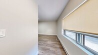 Located at 4141 Bathurst Street in Toronto's vibrant North York neighbourhood, this well-designed one-bedroom, one-bathroom unit offers a thoughtfully laid-out single-floor plan with clean, contemporary finishes throughout. Light wood-tone laminate flooring runs continuously across the living spaces, complementing the neutral warm-white walls and white baseboards to create a bright, cohesive aesthetic. The open-concept kitchen and living area serves as the heart of the unit. The kitchen is outfitted with crisp white shaker-style cabinetry, a classic white subway tile backsplash, dark countertops, and a full suite of stainless steel appliances including a refrigerator, stove, built-in dishwasher, and over-the-range microwave. A central island with a dark countertop provides additional workspace and a natural divider between the kitchen and the open living area, which benefits from a window allowing natural light to fill the space. The bedroom is a comfortable size, featuring a mirrored sliding-door closet that enhances the sense of space, a baseboard heating unit, and a small window. The bathroom features a dark wood-toned vanity with a stone-effect countertop, an undermount sink, modern fixtures, and clean tile flooring. The unit presents a well-maintained and move-in-ready living space.