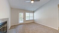 Located at 2833 S Mansion Dr in Independence, MO, this one-bedroom, two-bathroom single-floor home offers a thoughtfully designed layout with a clean, neutral palette throughout. The open living room is a standout feature, boasting vaulted ceilings, a ceiling fan, a tile-surround fireplace, and large windows alongside a private exterior door that invite abundant natural light and outdoor views. Plush carpeting flows throughout the living areas and bedroom, adding warmth to the space.

The galley-style kitchen is efficiently appointed with white cabinetry, light quartz countertops, stainless steel appliances including an electric range, refrigerator, and dishwasher, a deep sink with a modern faucet, and light hardwood-style flooring. A pass-through opening connects the kitchen to the living area.

The spacious primary bedroom comfortably accommodates large furnishings, features a ceiling fan, a walk-in closet, and direct access to one of the two bathrooms. Both bathrooms are finished with white cabinetry, quartz countertops, and tub-shower combinations with tiled surrounds. A hallway and additional closet provide practical storage. The textured ceilings and consistent neutral tones throughout give the home a cohesive, move-in-ready feel.