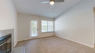 Located at 2833 S Mansion Dr in Independence, MO, this one-bedroom, two-bathroom single-floor home offers a thoughtfully designed layout with a clean, neutral palette throughout. The open living room is a standout feature, boasting vaulted ceilings, a ceiling fan, a tile-surround fireplace, and large windows alongside a private exterior door that invite abundant natural light and outdoor views. Plush carpeting flows throughout the living areas and bedroom, adding warmth to the space.

The galley-style kitchen is efficiently appointed with white cabinetry, light quartz countertops, stainless steel appliances including an electric range, refrigerator, and dishwasher, a deep sink with a modern faucet, and light hardwood-style flooring. A pass-through opening connects the kitchen to the living area.

The spacious primary bedroom comfortably accommodates large furnishings, features a ceiling fan, a walk-in closet, and direct access to one of the two bathrooms. Both bathrooms are finished with white cabinetry, quartz countertops, and tub-shower combinations with tiled surrounds. A hallway and additional closet provide practical storage. The textured ceilings and consistent neutral tones throughout give the home a cohesive, move-in-ready feel.