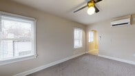 Located at 225 S 400 E in Salt Lake City, Utah, this single-floor residence blends classic architectural details with modern upgrades throughout. The living area features soft carpeting, neutral warm-toned walls, multiple windows with white blinds that invite natural light, a ceiling fan with a gold accent fixture, and a charming arched doorway that adds character to the space. The thoughtfully renovated kitchen is a standout, showcasing deep slate-blue shaker-style cabinetry paired with striking granite countertops, a white subway tile backsplash, brushed gold hardware and faucet, and a full suite of stainless steel appliances including a gas range, dishwasher, and over-the-range microwave. The bedrooms continue the warm, neutral palette with plush carpeting and ample natural light provided by white-trimmed windows. Ceiling fans with gold fixtures are featured in multiple rooms, maintaining a cohesive design language throughout. The bathroom is elegantly appointed with white subway tile surrounding a soaking tub, marble-look tile flooring, a pedestal sink, and gold fixtures that tie together the home's consistent accent theme. The overall ambiance is clean, bright, and move-in ready, with a well-considered balance of classic detailing and contemporary finishes.