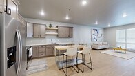Located at 3911 20th Ave S in Fargo, North Dakota, this thoughtfully designed one-bedroom, one-bathroom unit offers a comfortable and modern living experience across a single floor. The open-concept layout seamlessly connects the kitchen and living room, creating an inviting and functional shared space. The kitchen is outfitted with warm-toned shaker-style cabinetry, open shelving, light quartz countertops, and stainless steel appliances including a refrigerator, range, microwave, and dishwasher. A butcher block island with seating for two serves as a practical centerpiece for dining and entertaining. The living area features light hardwood-style flooring, recessed lighting, and a large window that brings in natural light, complemented by a stylish neutral-toned sofa and bold abstract artwork. The bedroom is a calm retreat with plush carpeting, a ceiling fan, a window with outdoor views, and ample space for furnishings. The bathroom showcases a dark-stained vanity with a framed mirror, modern light fixture, and light flooring for a clean, contemporary finish. A dedicated closet and entrance area complete this well-organized, move-in-ready unit.