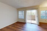 Located at 5207 Hollytree Dr in Tyler, TX, this one-bedroom, one-bathroom residence offers a thoughtfully laid-out single-floor plan. Rich hardwood-style flooring flows throughout the main living areas, creating a warm and cohesive aesthetic. The living room is bright and inviting, featuring a sliding glass door flanked by a window, allowing abundant natural light and direct access to an outdoor space. A textured ceiling adds a classic touch throughout the unit.

The kitchen is efficiently designed with warm wood cabinetry, dark countertops, and a peninsula-style breakfast bar that opens to the dining area — ideal for casual meals and entertaining. The dining area benefits from a charming chandelier and a window with views of the surrounding greenery.

A hallway connects the main living areas to the private spaces. The bedroom is generously sized, carpeted for comfort, and features two windows that invite natural light from multiple directions, along with a ceiling fan. Notably, the bedroom includes access to three closets, offering exceptional storage. A full bathroom completes this well-organized home, making it a practical and comfortable living space in Tyler, TX.