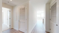 Located in the heart of Atlanta's Buckhead neighborhood, this 2-bedroom, 3-bathroom residence offers a refined modern living experience. The open-concept kitchen and living area is anchored by a large white quartz peninsula, ideal for dining and entertaining. The kitchen features grey shaker-style cabinetry extending to the ceiling, a white tile backsplash, and a full suite of stainless steel appliances including a gas range, built-in microwave, and French door refrigerator. Light hardwood flooring flows throughout the main living areas, complemented by recessed and accent lighting.

The primary bedroom is generously proportioned, boasting corner floor-to-ceiling windows that frame sweeping panoramic views of the Atlanta skyline and surrounding greenery, with a ceiling fan adding comfort. It connects to a spacious en-suite bathroom featuring a glass-enclosed walk-in shower, large-format tile flooring, and tall windows that continue the view. A walk-in closet with built-in wire shelving provides ample storage. The second bedroom is carpeted, sun-drenched, and offers direct access to its own bathroom. Three well-appointed closets and a connecting hallway with louvered doors round out this well-designed residence.