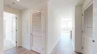 Located in the heart of Atlanta's Buckhead neighborhood, this 2-bedroom, 3-bathroom residence offers a refined modern living experience. The open-concept kitchen and living area is anchored by a large white quartz peninsula, ideal for dining and entertaining. The kitchen features grey shaker-style cabinetry extending to the ceiling, a white tile backsplash, and a full suite of stainless steel appliances including a gas range, built-in microwave, and French door refrigerator. Light hardwood flooring flows throughout the main living areas, complemented by recessed and accent lighting.

The primary bedroom is generously proportioned, boasting corner floor-to-ceiling windows that frame sweeping panoramic views of the Atlanta skyline and surrounding greenery, with a ceiling fan adding comfort. It connects to a spacious en-suite bathroom featuring a glass-enclosed walk-in shower, large-format tile flooring, and tall windows that continue the view. A walk-in closet with built-in wire shelving provides ample storage. The second bedroom is carpeted, sun-drenched, and offers direct access to its own bathroom. Three well-appointed closets and a connecting hallway with louvered doors round out this well-designed residence.