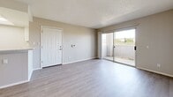 Located at 43530 Gadsden Ave in Lancaster, CA, this 2-bedroom, 1-bathroom single-floor unit offers a clean, neutral aesthetic throughout. Light wood-style flooring and soft gray walls create a cohesive, modern feel across every room. The open-concept living area is bright and functional, with a ceiling fan overhead and a sliding glass door that opens to a private balcony, bringing in natural light and outdoor views. A peninsula counter connects the living space to the kitchen, which features white cabinetry with ample storage, light stone-finish countertops, a gas range, an under-cabinet range hood, and a stainless steel sink. Both bedrooms are well-proportioned, with the primary bedroom offering generous closet space behind sliding panel doors. The second bedroom includes a window with vertical blinds. A hallway connects the bedrooms to the shared full bathroom, which is equipped with a white vanity with stone-finish countertops and a tub/shower combination. Textured ceilings are present throughout, and clean white trim and baseboards lend a polished finish to the space. The layout is practical and efficient, making the most of the available footprint.