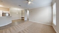 Located at 1932 Stanton Rd in East Point, GA, this one-bedroom, one-bathroom unit offers a thoughtfully laid-out single-floor plan. The open-concept living, dining, and kitchen area forms the heart of the home, with wood-style plank flooring flowing throughout. The kitchen is outfitted with white shaker cabinetry, light stone countertops, stainless steel appliances including a refrigerator and range, and a built-in microwave hood — all combining for a clean, modern aesthetic. A decorative pendant light and chair-rail molding accent the dining area, adding a touch of character. The living area features plush carpeting and a ceiling fan with light fixture, creating a comfortable and welcoming atmosphere. The spacious bedroom is carpeted, bathed in natural light from large windows with views of the surrounding neighborhood, and includes a ceiling fan and ample closet space with two dedicated closets. Crown molding adds a refined finish to the bedroom. The bathroom includes a full tub-shower combination with clean white surrounds. Additional conveniences include a dedicated laundry space and a utility room, rounding out this well-equipped and efficiently designed home.
